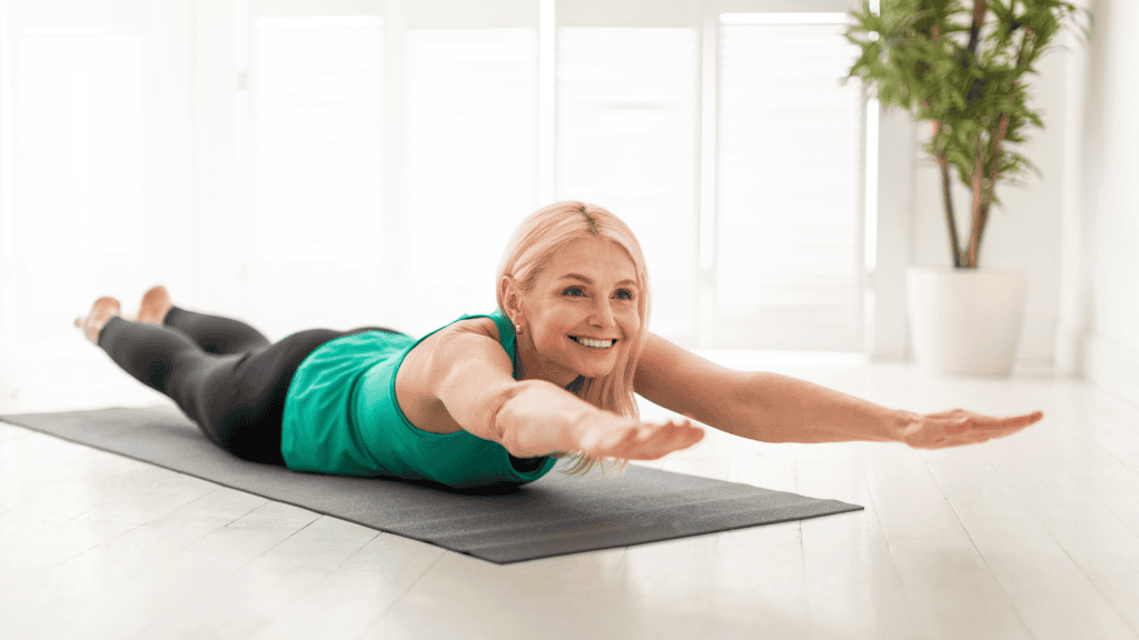 Sporty Senior Woman Making Superman Exercise While Training At Home