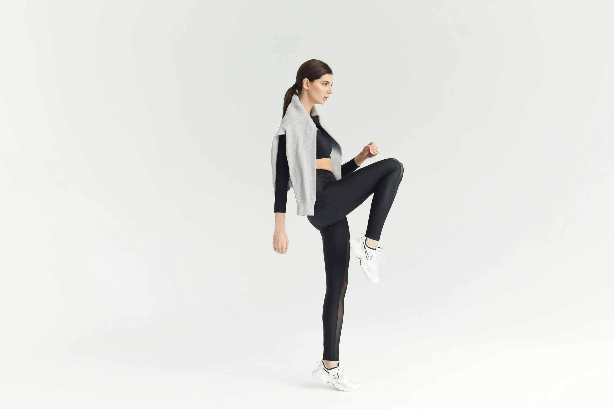 Woman Exercising with a Gray Sweater Hanging at Her Back Woman Exercising with a Gray Sweater Hanging at Her Back
