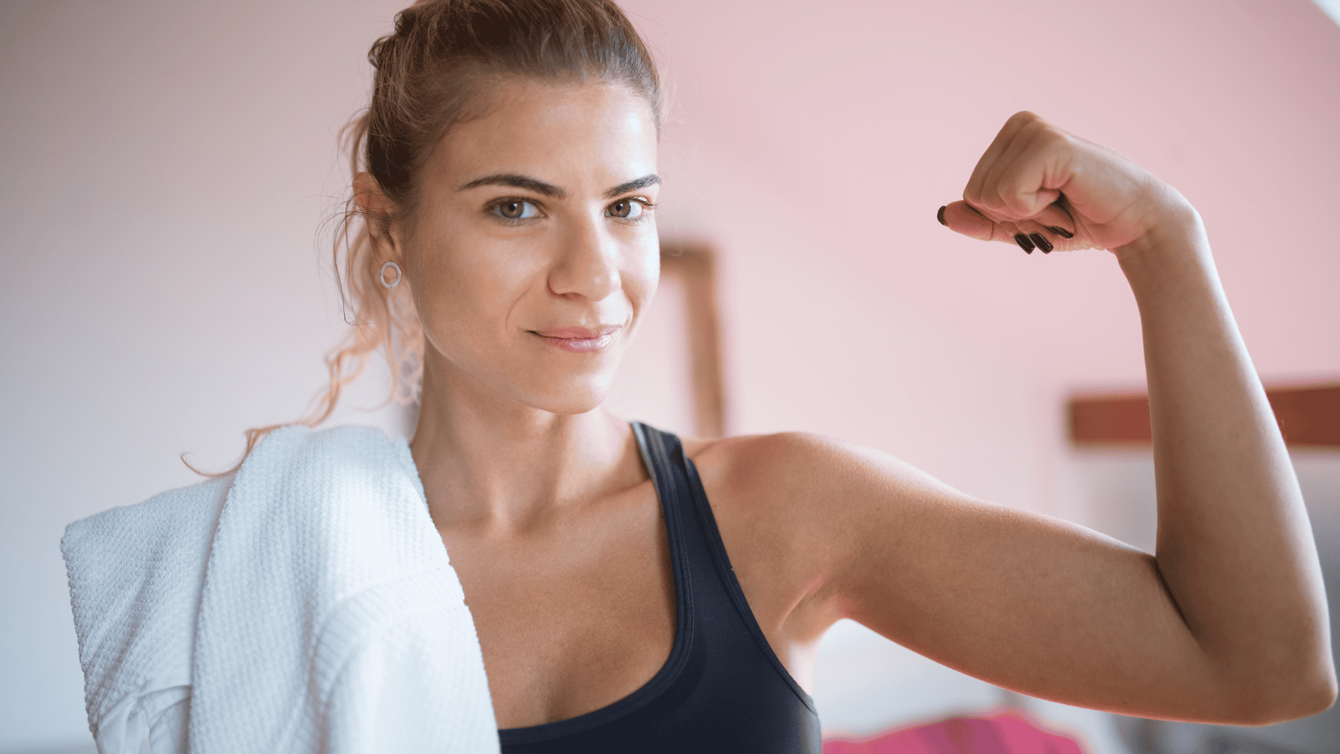 A Woman Flexing Her Arm with a towel on her shoulder