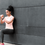 Athlete doing wall squat on city street