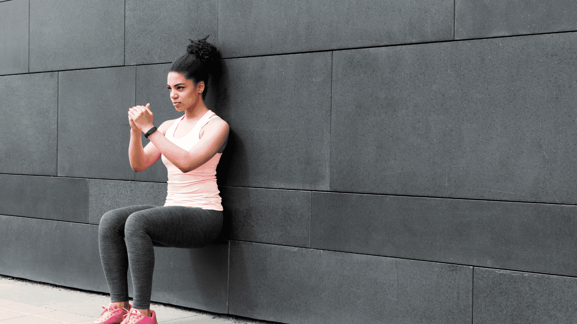 Athlete doing wall squat on city street