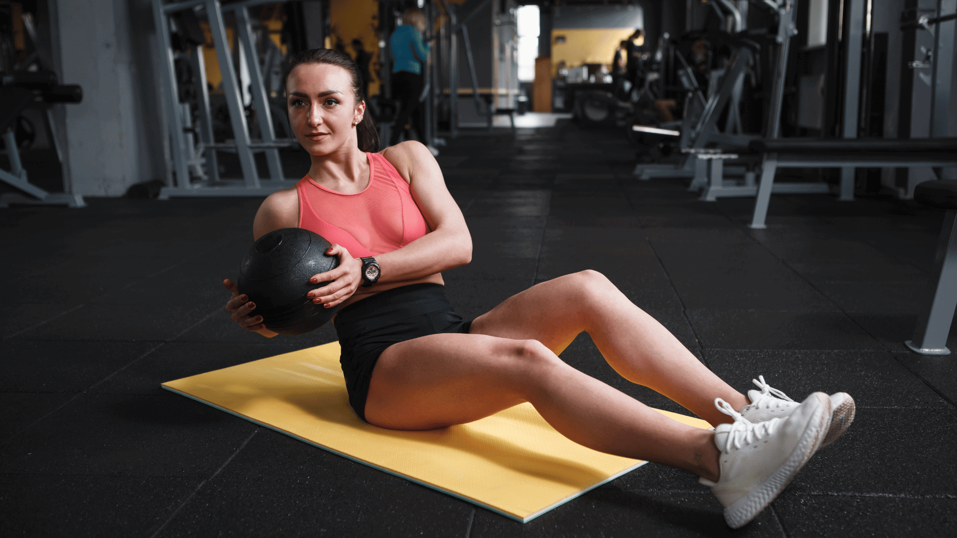 Female athlete doing russian twist, holding medicine ball