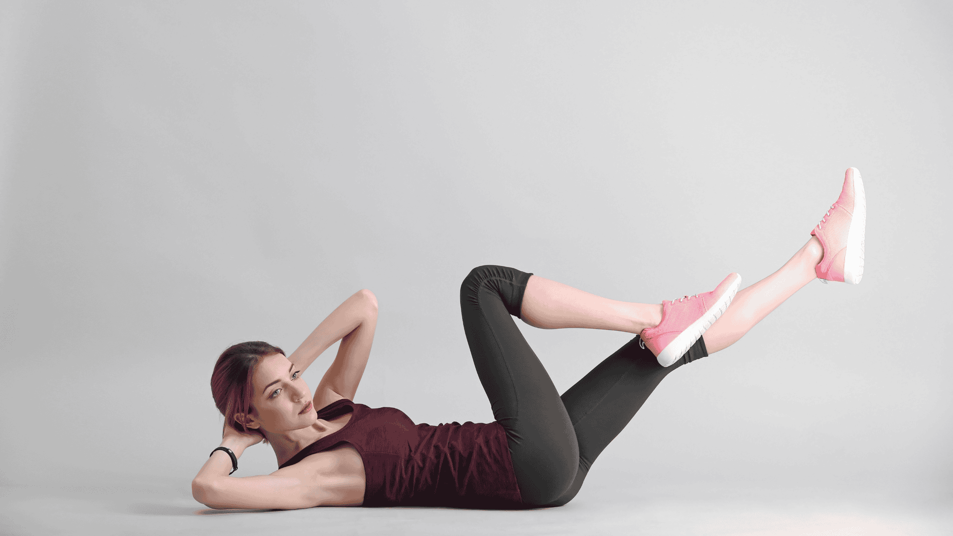 Woman Doing Bicycle Crunch on Light Background