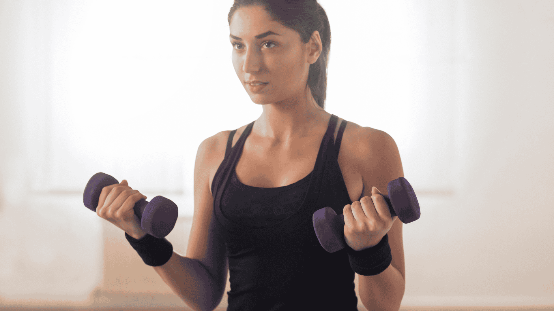 Woman doing a bicep workout at home Woman doing a bicep workout at home