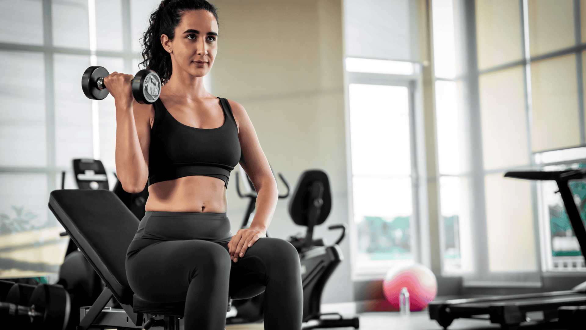 Woman exercising in the gym by lifting weights
