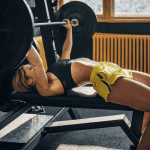 A lady doing a barbell bench press