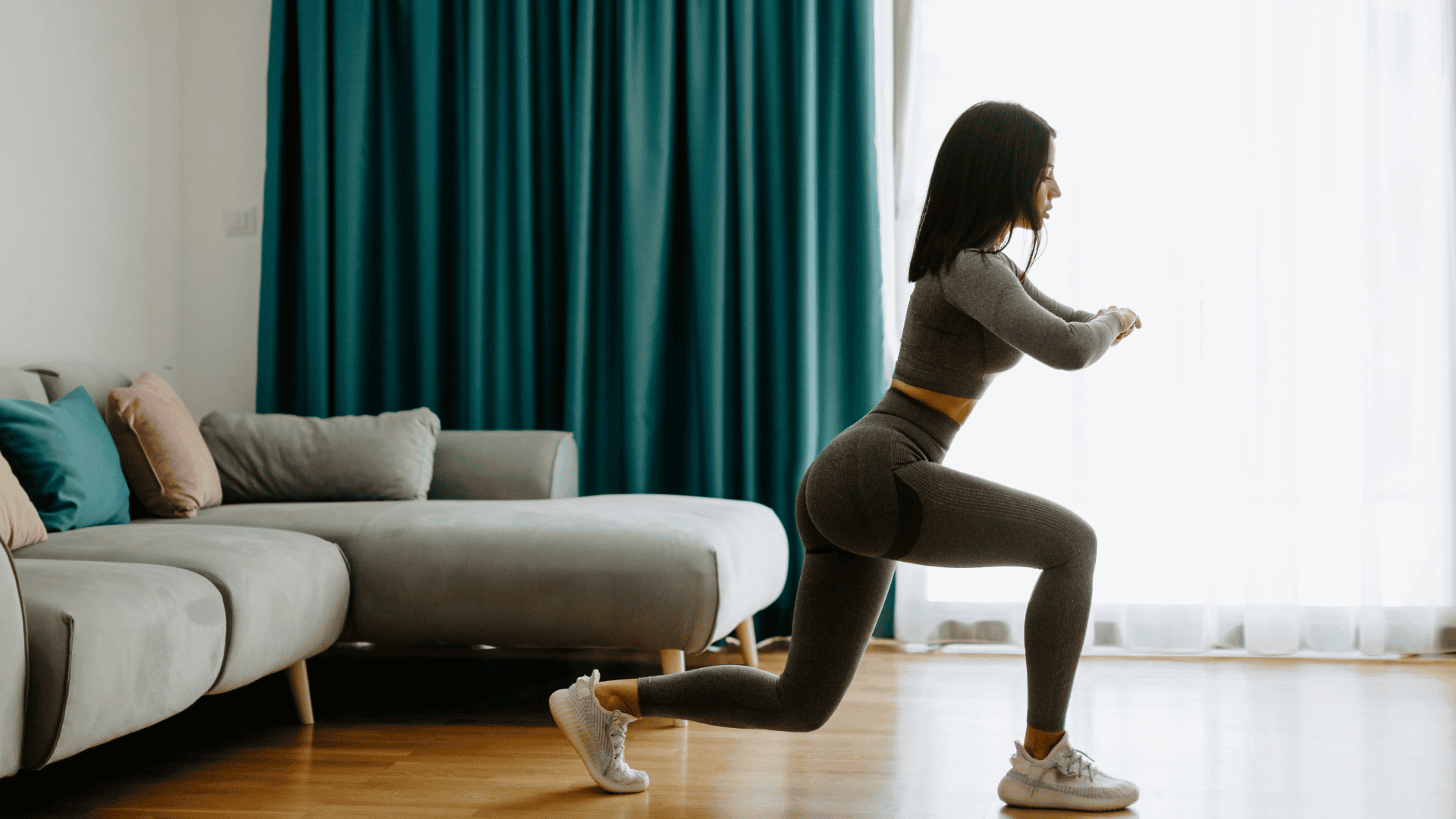 AN Overlay Template - 2025-08-19T165540.949 Woman doing a lunge exercise in a living room, wearing a matching workout set.