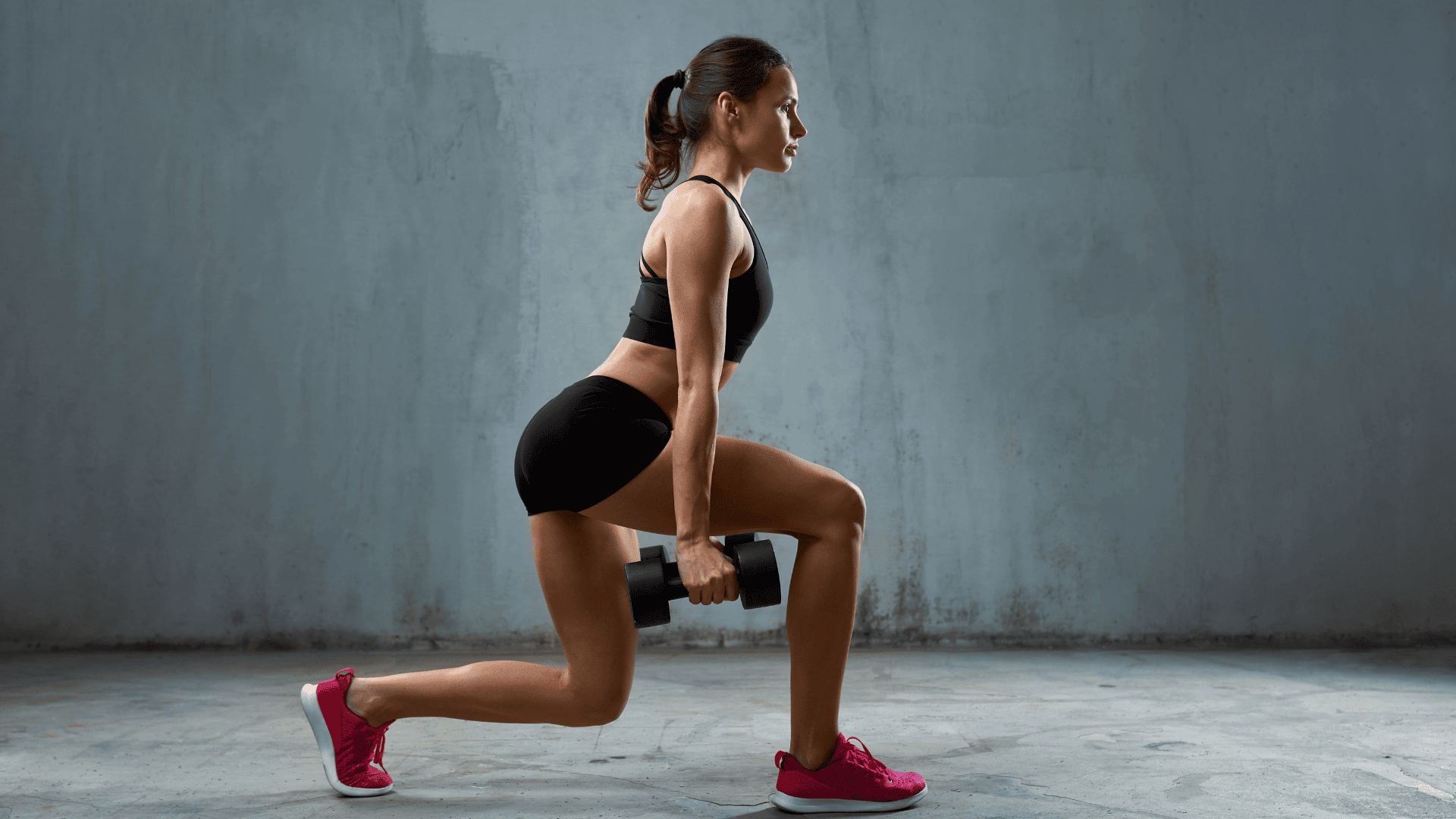 Woman performing reverse lunges with dumbbells