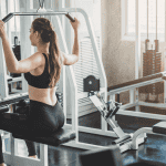 woman doing lat pull pull down exercise in fitness gym