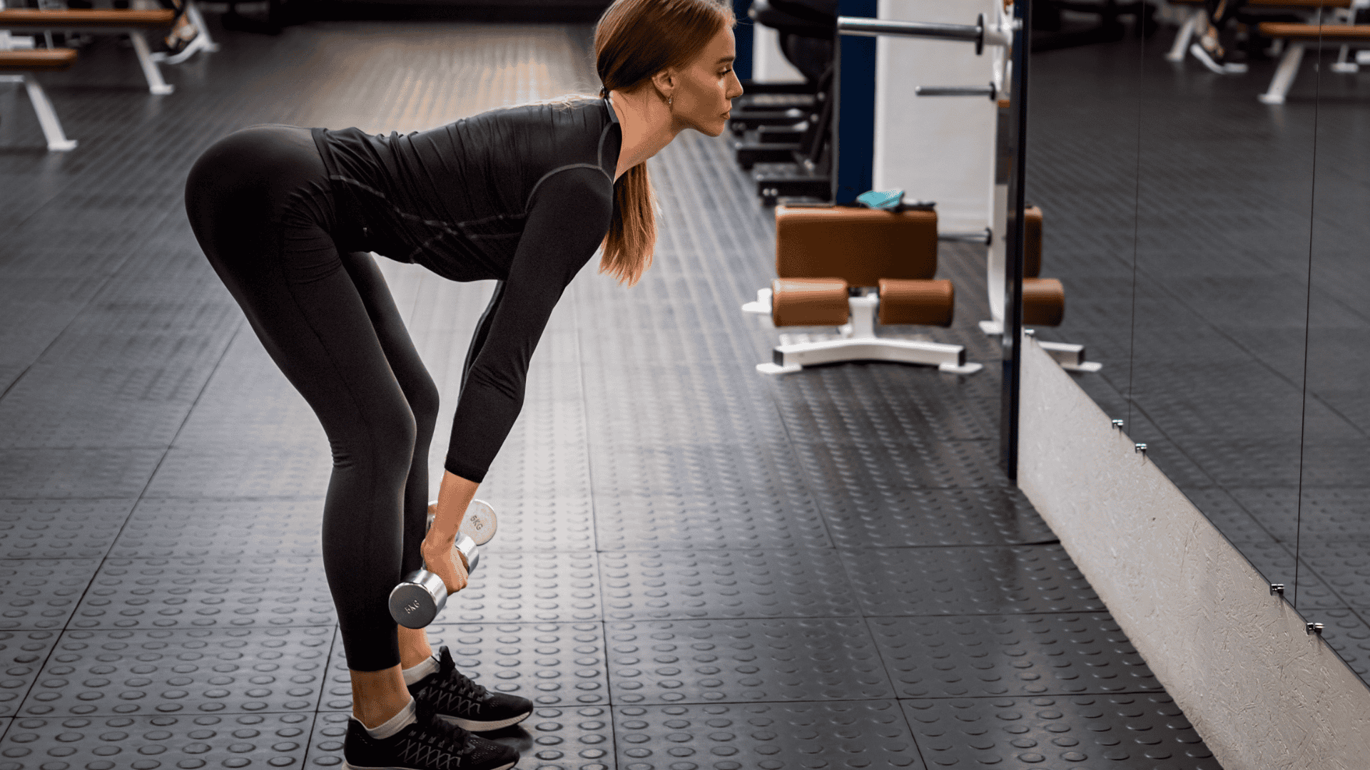 A lady doing romanian deadlifts on a gym
