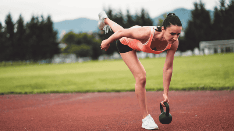 A lady doing kettleball training outdoor