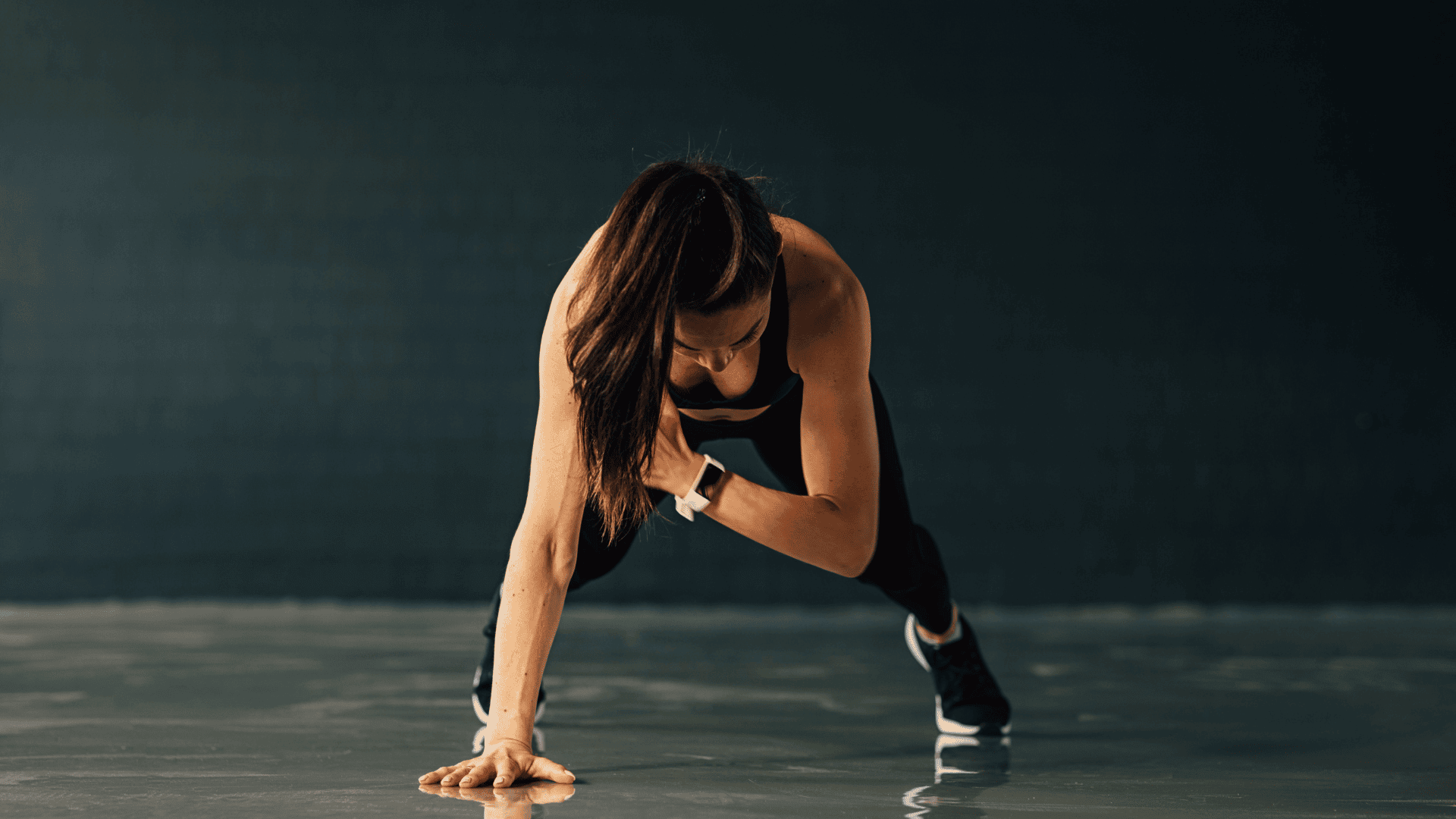 woman performing plank shoulder taps to engage her core and upper body.